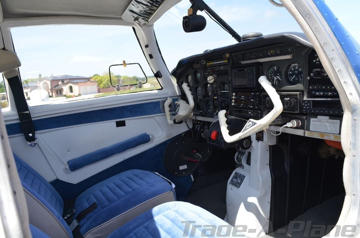 Wide view of the Mooney Executive 21 aircraft's cockpit and front seats.