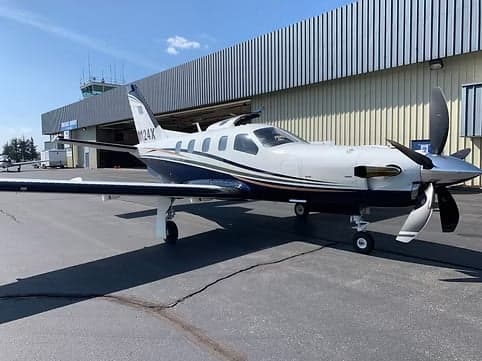 Side view of a turboprop aircraft with registration N124X parked on the tarmac.