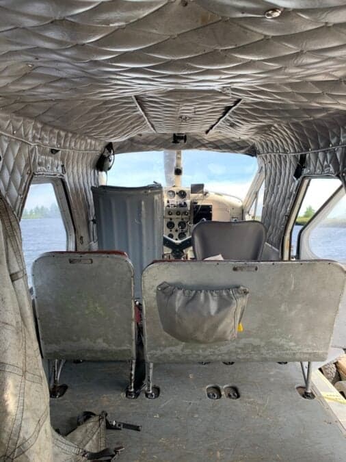 The interior of the aircraft shows the rear seats and the cockpit.