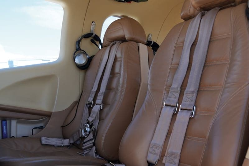 Close-up of the tan leather seats in the aircraft cabin.