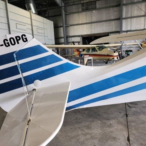 Tail section of a white and blue aircraft with registration C-GOPG.