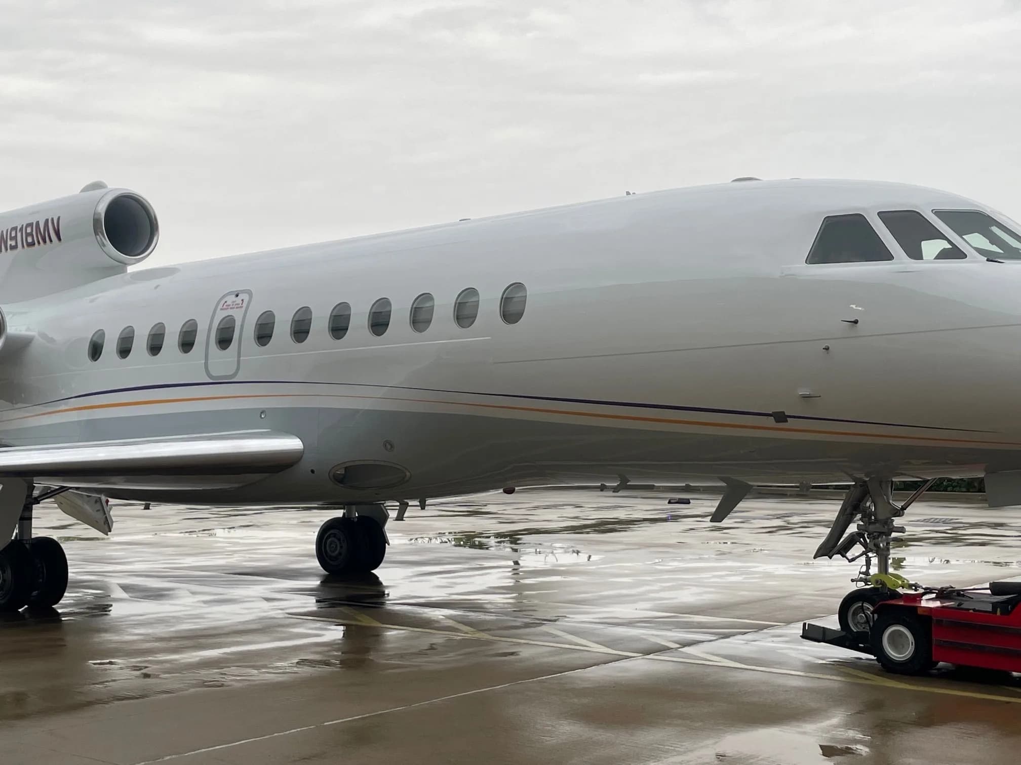 A Falcon aircraft with registration N918MV is parked on the tarmac.