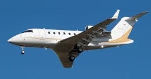 Aircraft N11A in flight with a white and gold paint scheme.