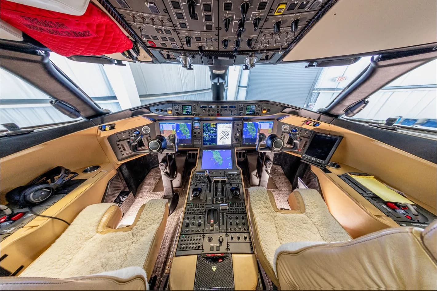 View of the aircraft's cockpit with beige seats and modern avionics.