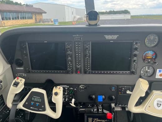 Front view of a Beechcraft Bonanza with the engine cowling open.