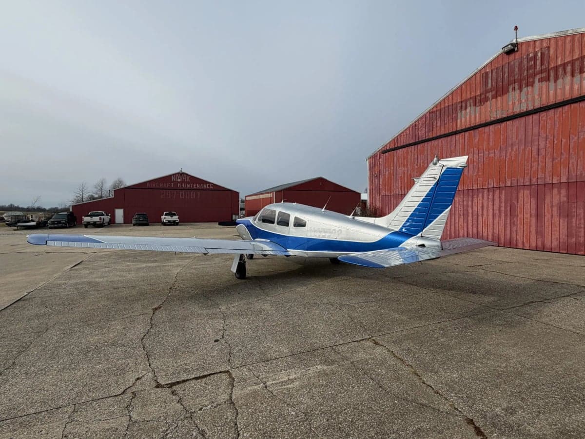 A Piper PA-28-181 Archer II aircraft with registration N47723 parked on the tarmac in front of a hangar.
