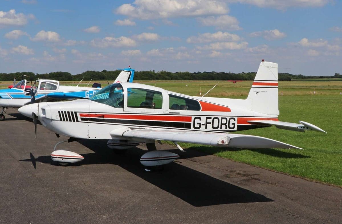A Mooney M20C aircraft with registration G-FORG parked on the tarmac.