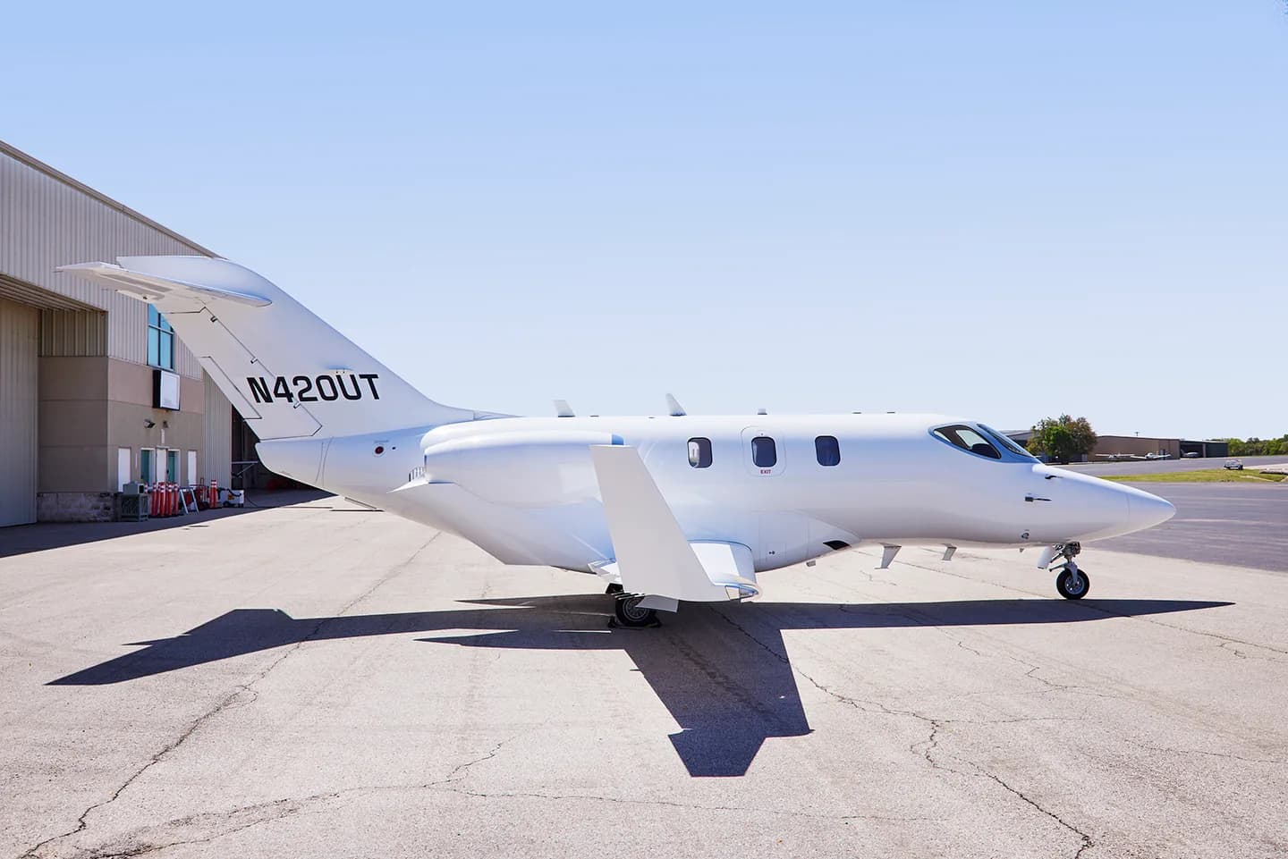 Side view of a white HondaJet N420UT on the tarmac.