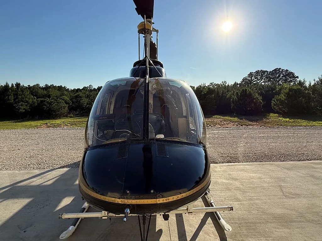 A head-on view of the black and gold helicopter, N887EH, showing its large front windshield.