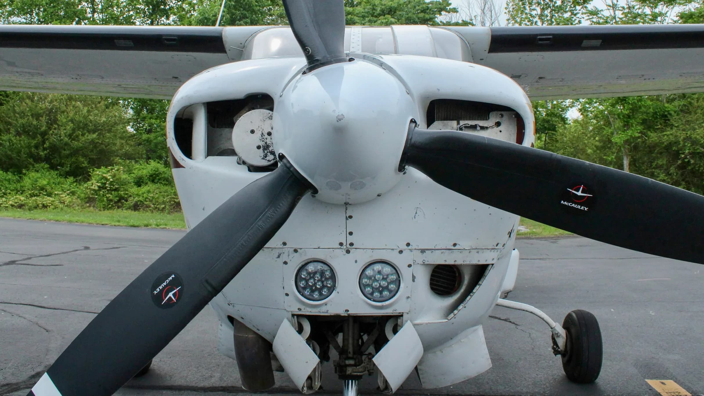 A close-up front view of the Cessna P210N Centurion, showing its propeller and nose with LED landing lights.