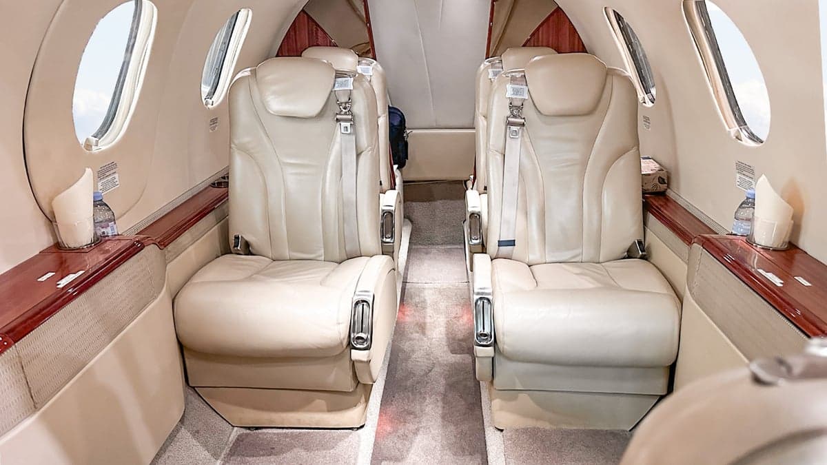 Aircraft interior with leather seats and wood trim.