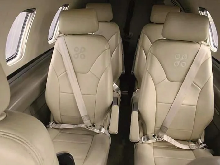 Interior view of the aircraft cabin with cream-colored leather seats.