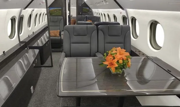 View of the interior cabin of an aircraft with a table and seats.