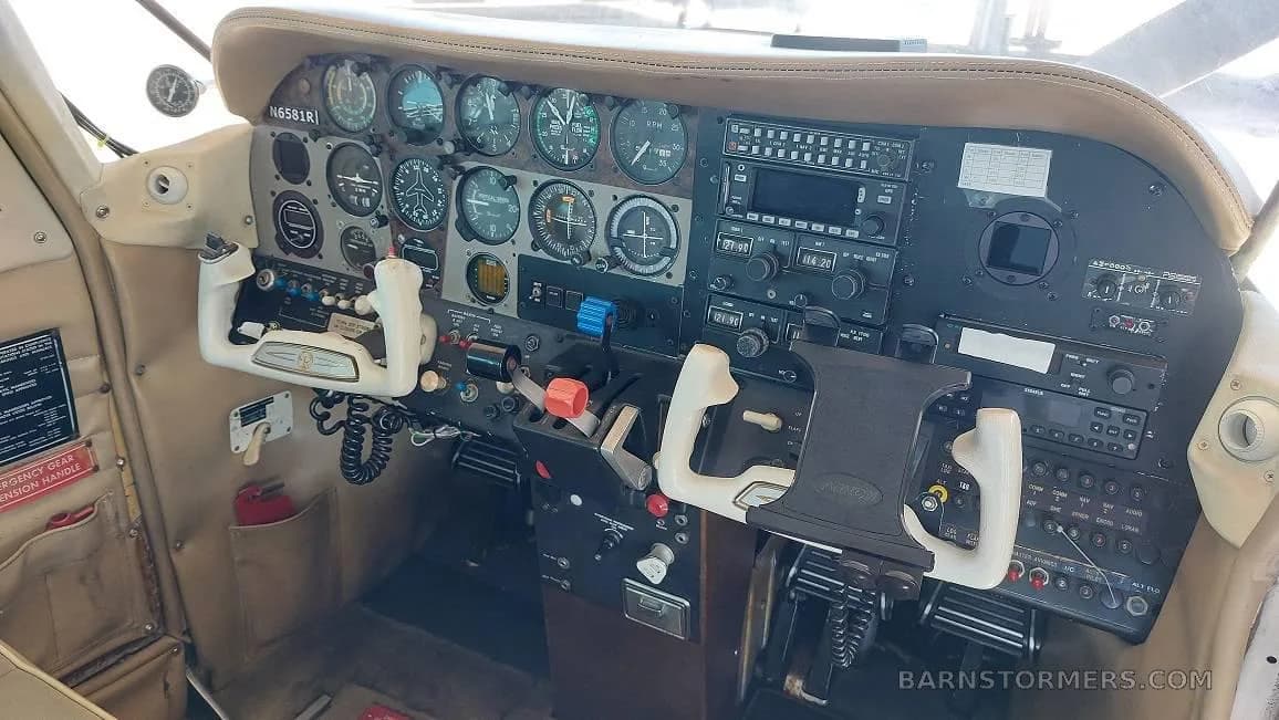 The instrument panel and dual yokes of a small aircraft cockpit, showing various gauges and avionics.