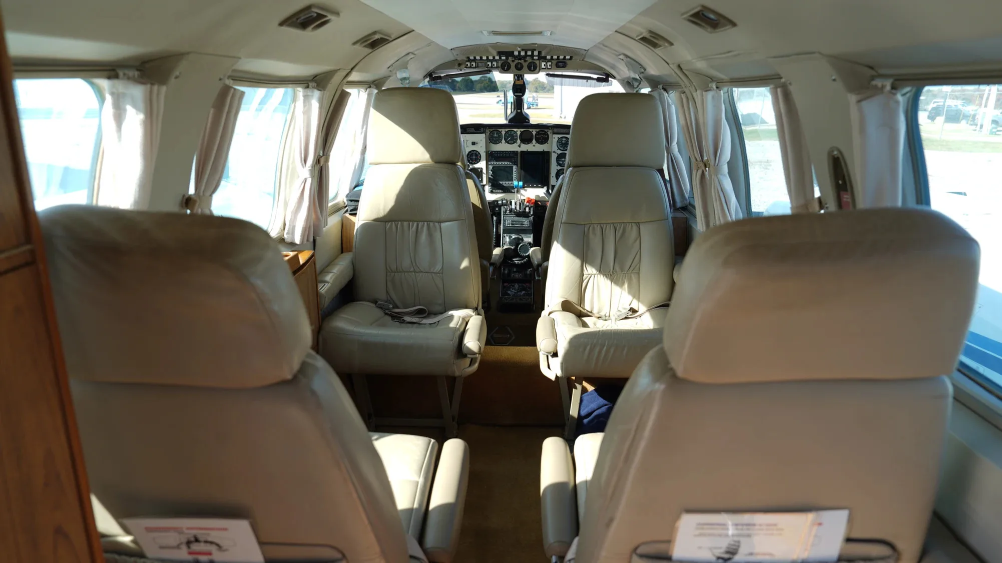 View of the aircraft's interior with four seats and the cockpit in the background.