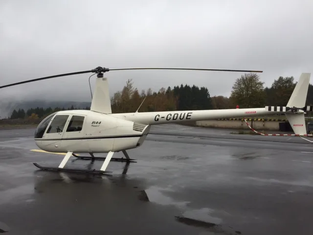Robinson R44 Raven on the tarmac with a white paint scheme.