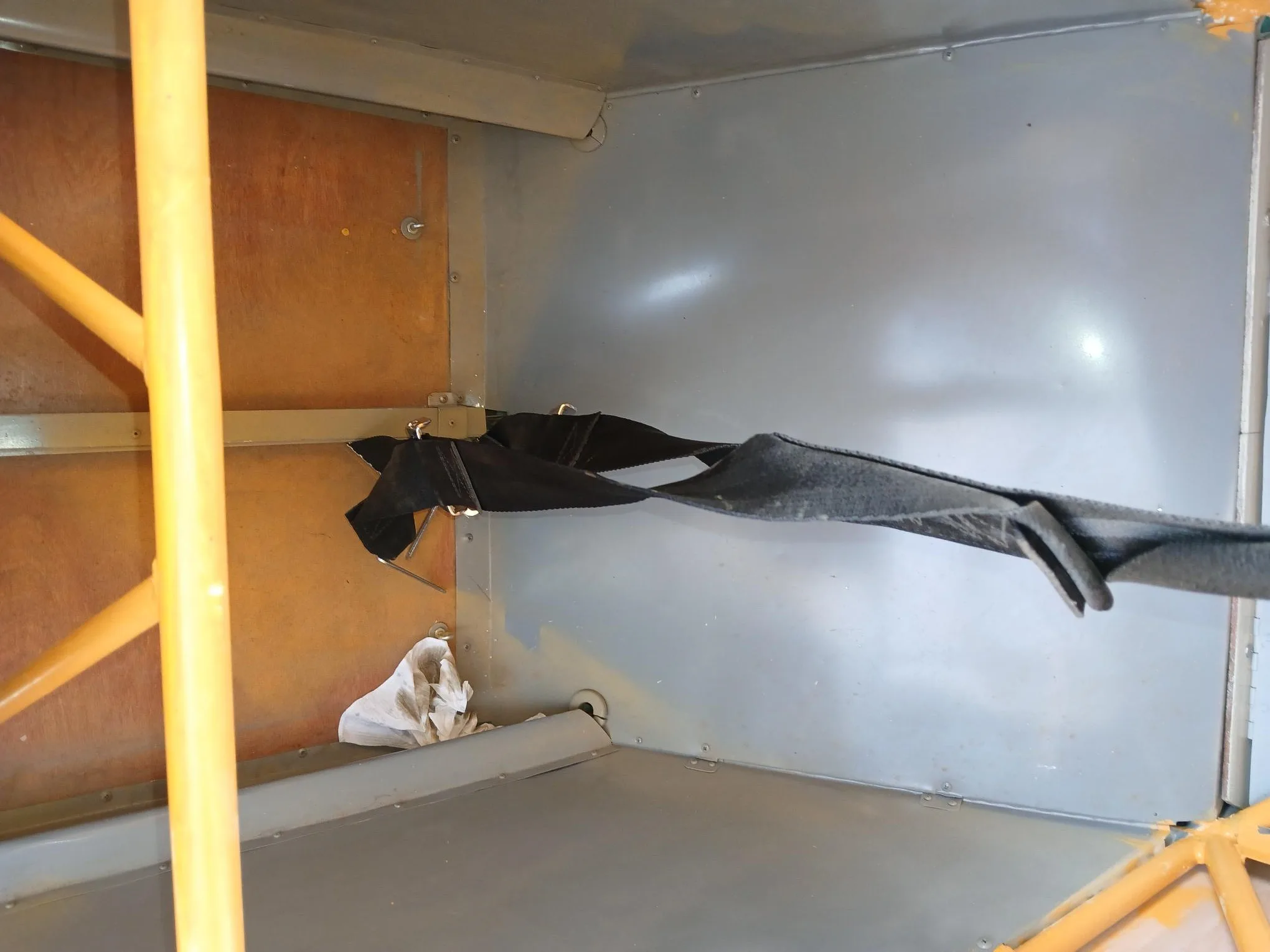 The rear interior cabin area of the aircraft, showing the metal and wood structure.