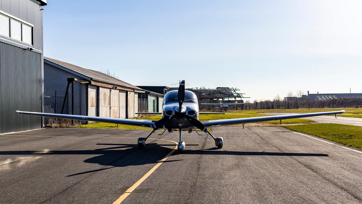 Front view of the silver Cirrus OY-TEG on the tarmac.
