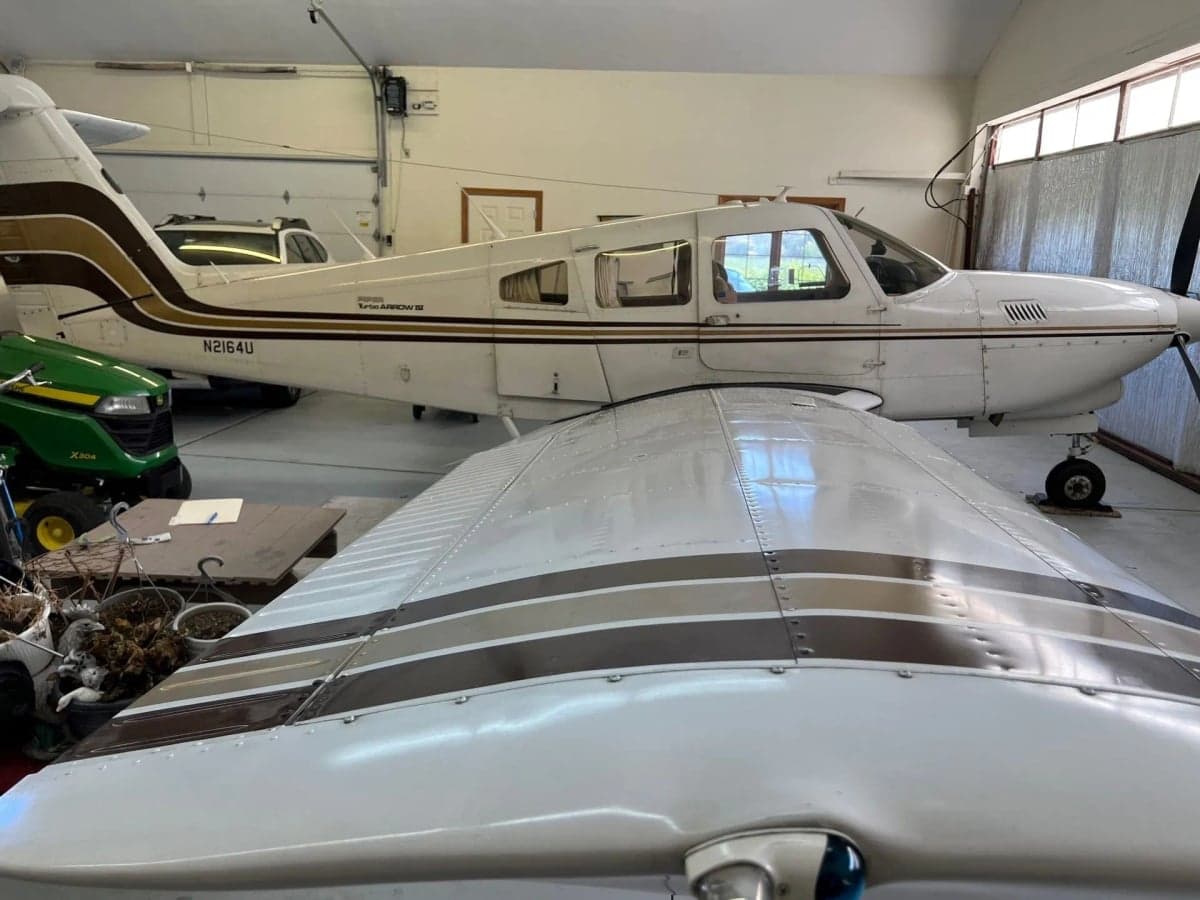 A Piper Turbo Arrow III aircraft parked inside a hangar.