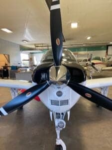 Close up of the propeller and nose of a Beechcraft Bonanza.