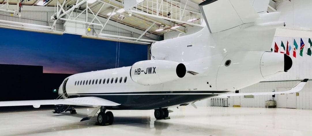 Rear view of the HB-JWX aircraft inside a hangar.