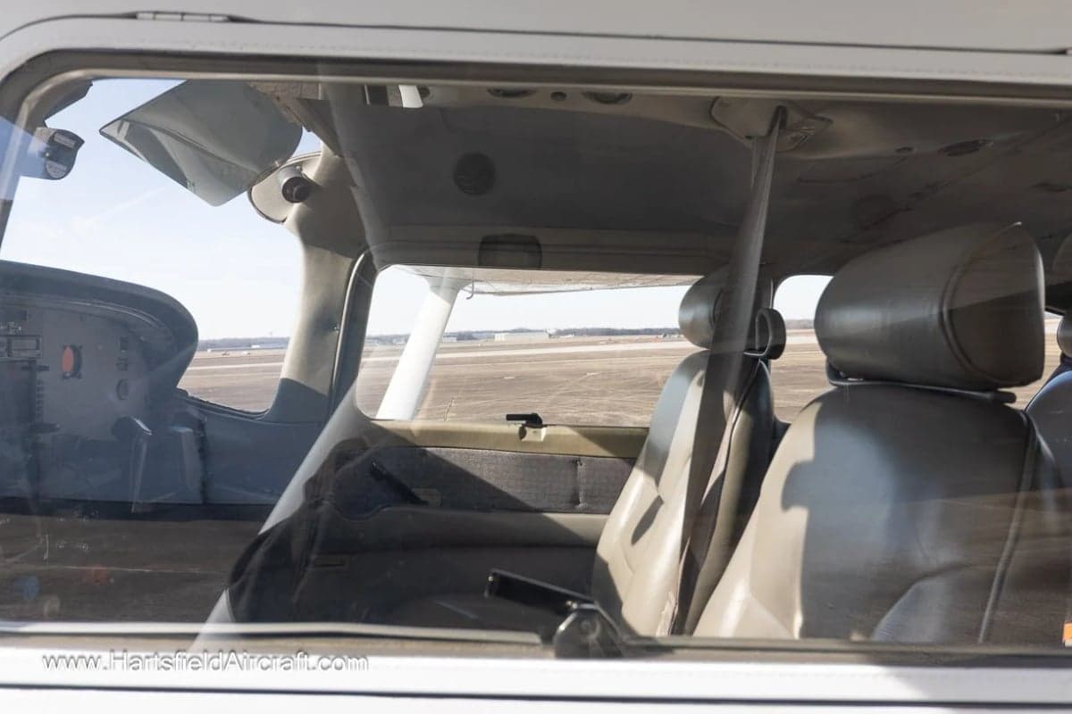 View of the interior seats and cockpit of an aircraft through the window.