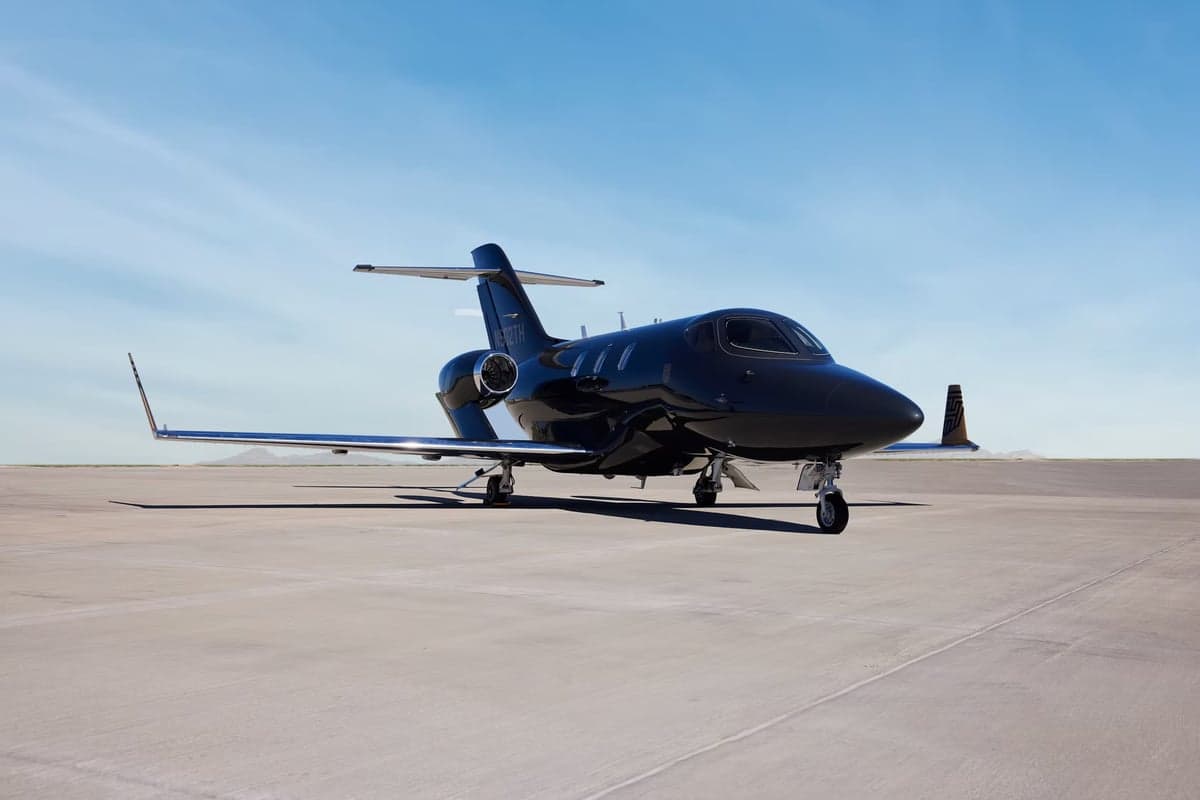 Side view of a black HondaJet on the tarmac.