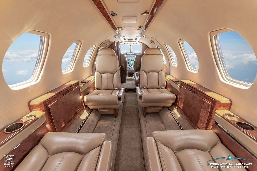 The luxurious tan leather interior of the Cessna Citation V cabin, looking forward towards the cockpit.