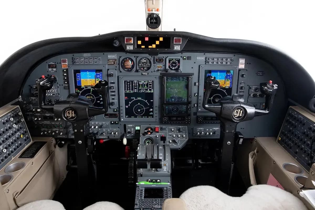 The cockpit features a modern glass panel display with multiple screens and control yokes.