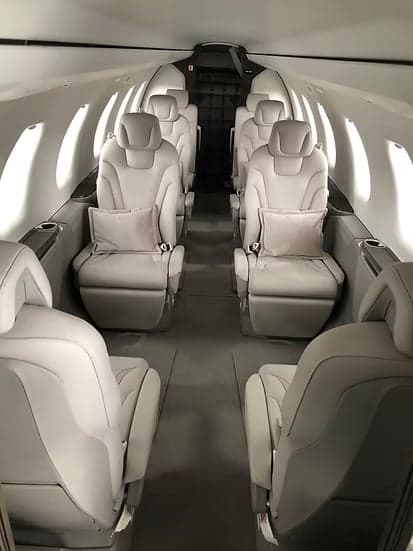A view down the aisle of the aircraft cabin with seating.