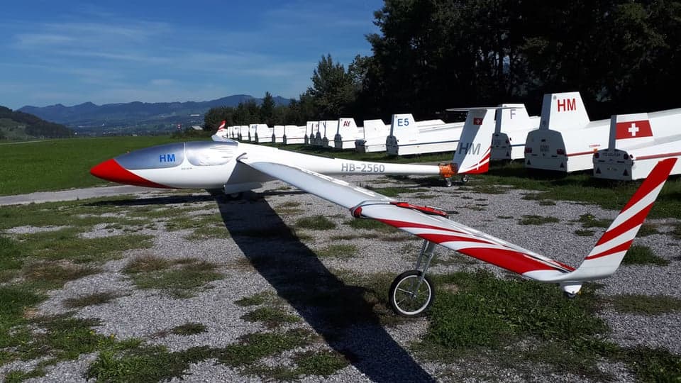 HB-2560 glider parked with other gliders in the background.