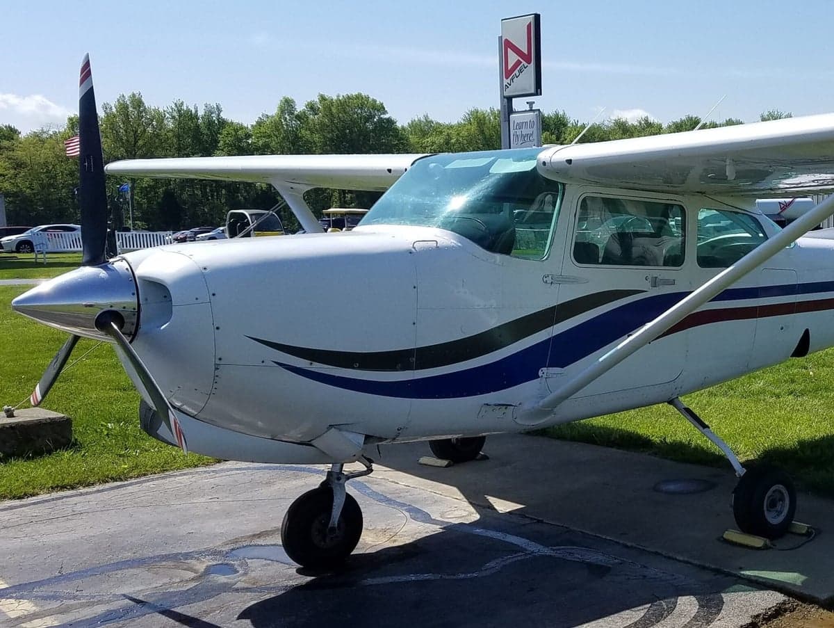 Cessna 172 Skyhawk with a white and red paint scheme inside a hangar.