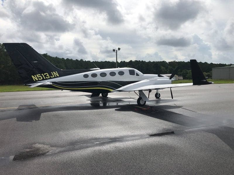 The N513JN aircraft is parked on the tarmac with a black and white paint scheme.