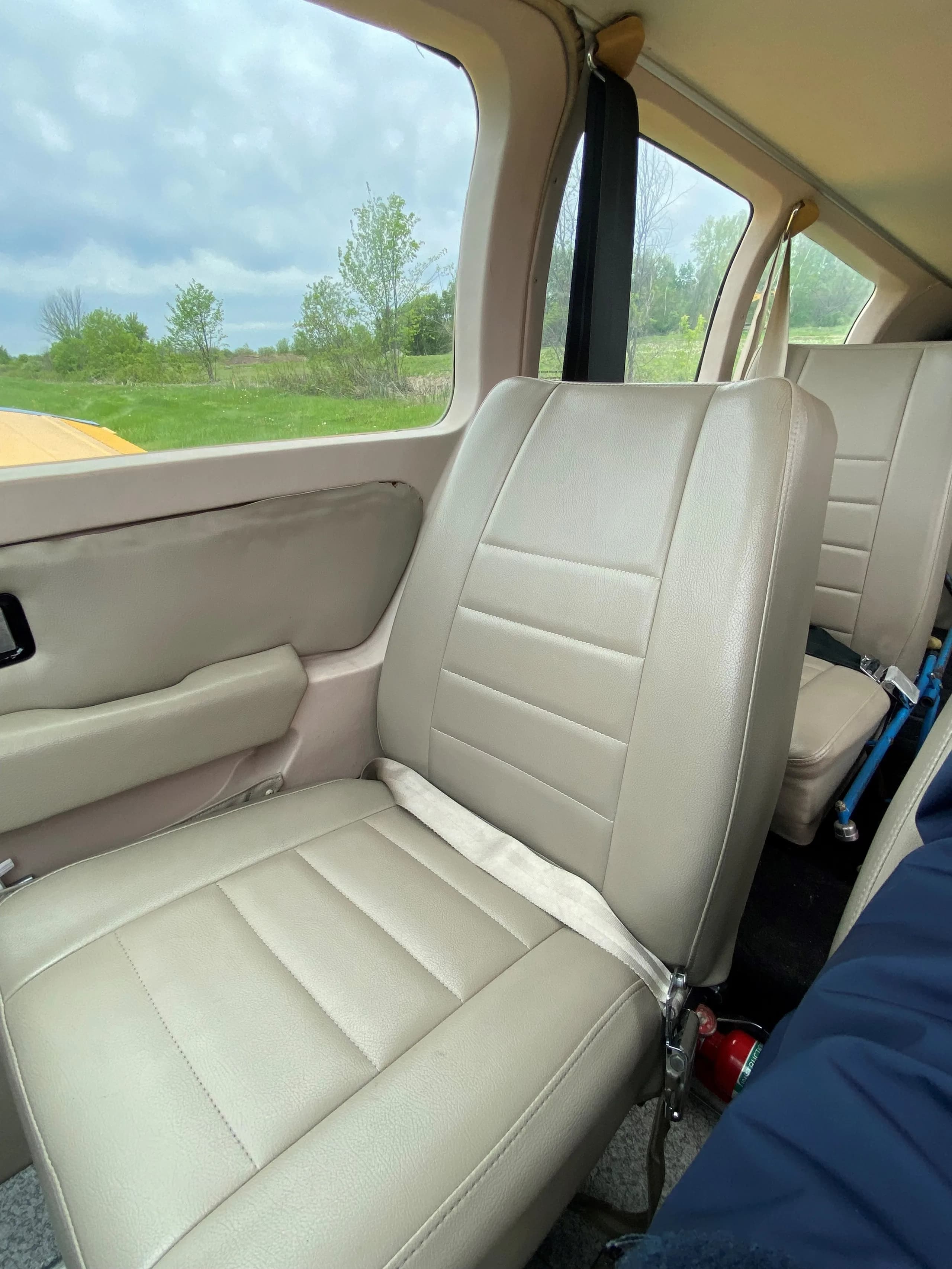 A close-up of the beige rear passenger seat in the aircraft cabin.