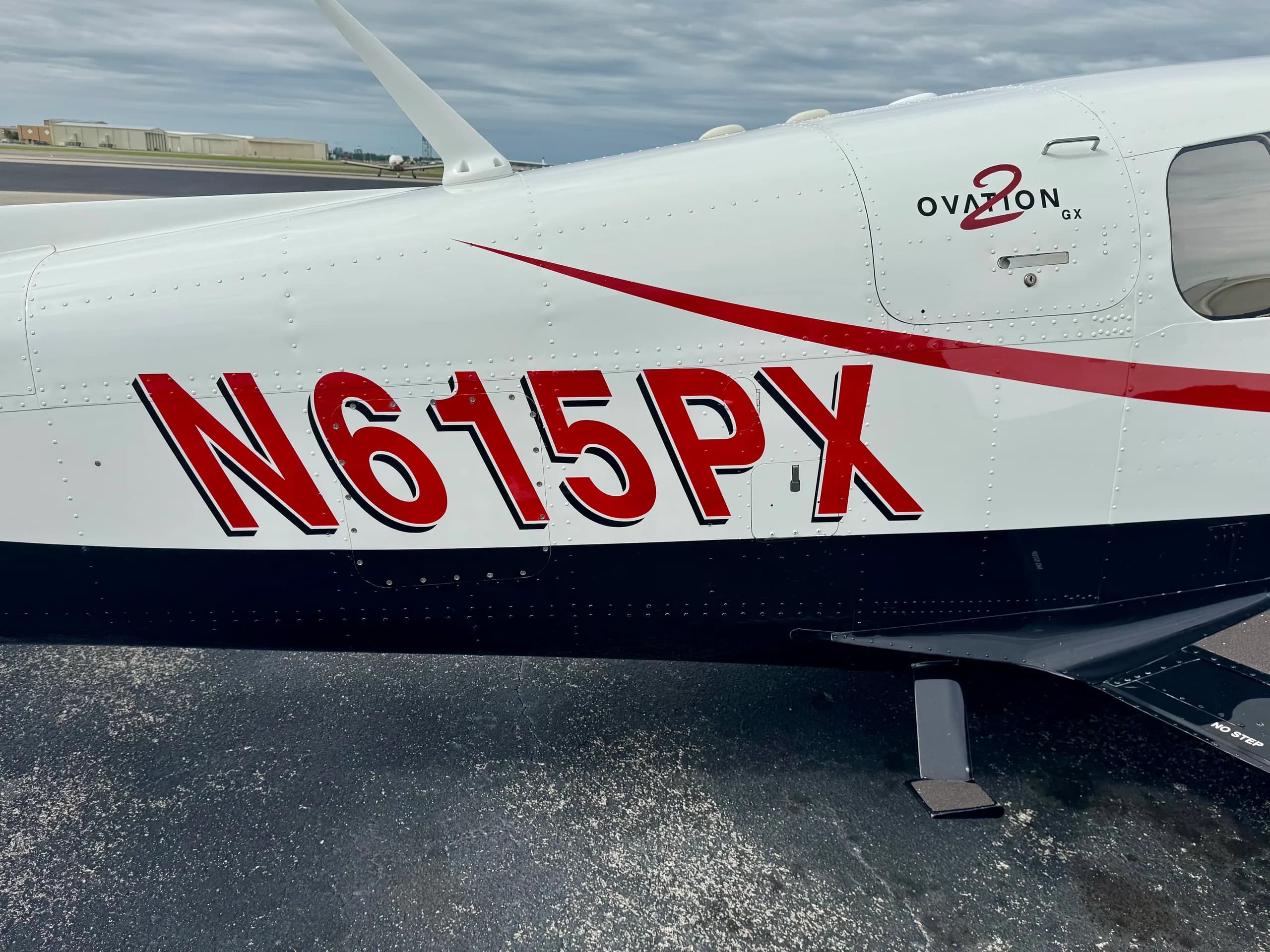 A close-up view of the fuselage of Mooney Ovation GX N615PX, highlighting the red N-number and "Ovation 2 GX" branding.