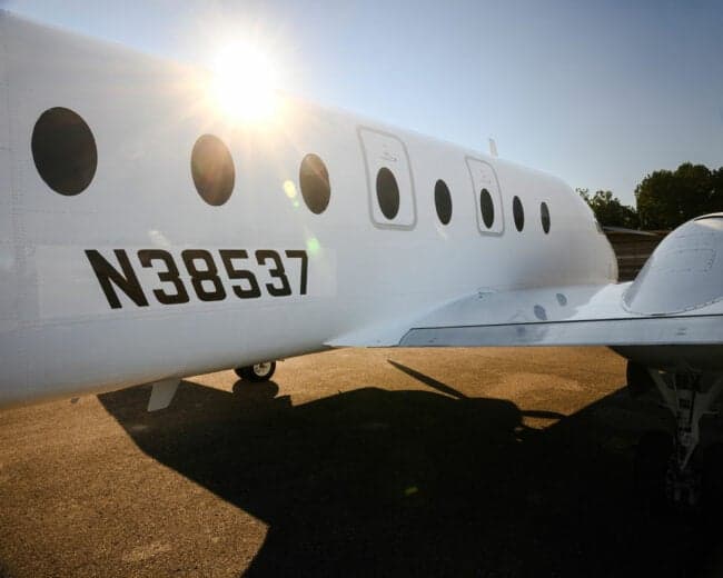 A white turboprop aircraft parked on a tarmac.