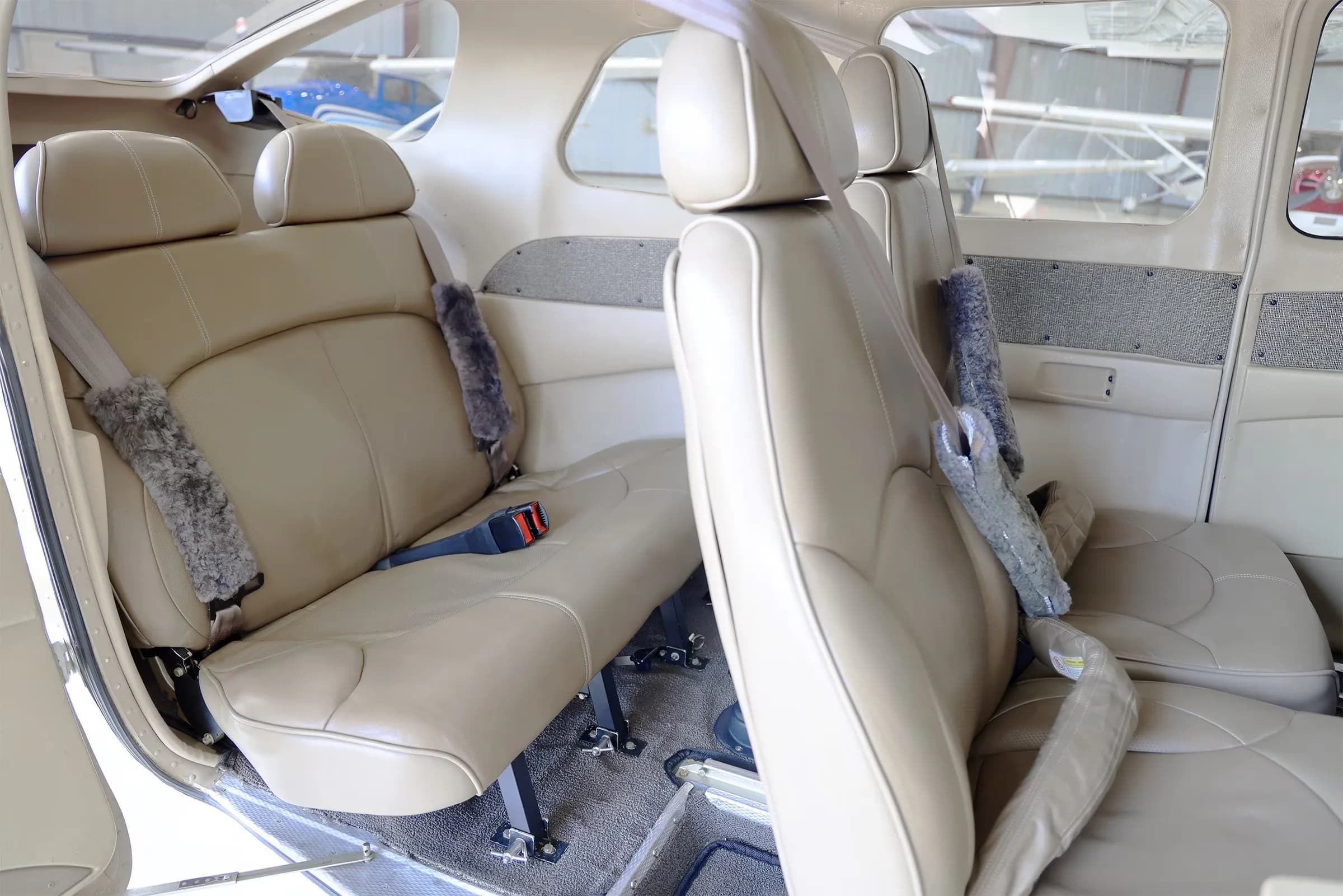The tan leather interior cabin of a Cessna 206 Stationair TC aircraft, showing multiple rows of seats.