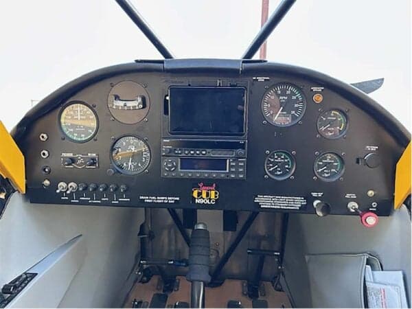 Full view of the instrument panel with gauges and avionics in the N90LC Legend Cub cockpit.