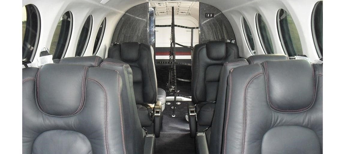 The interior of the Beechcraft King Air 350 features black leather seats with red stitching.