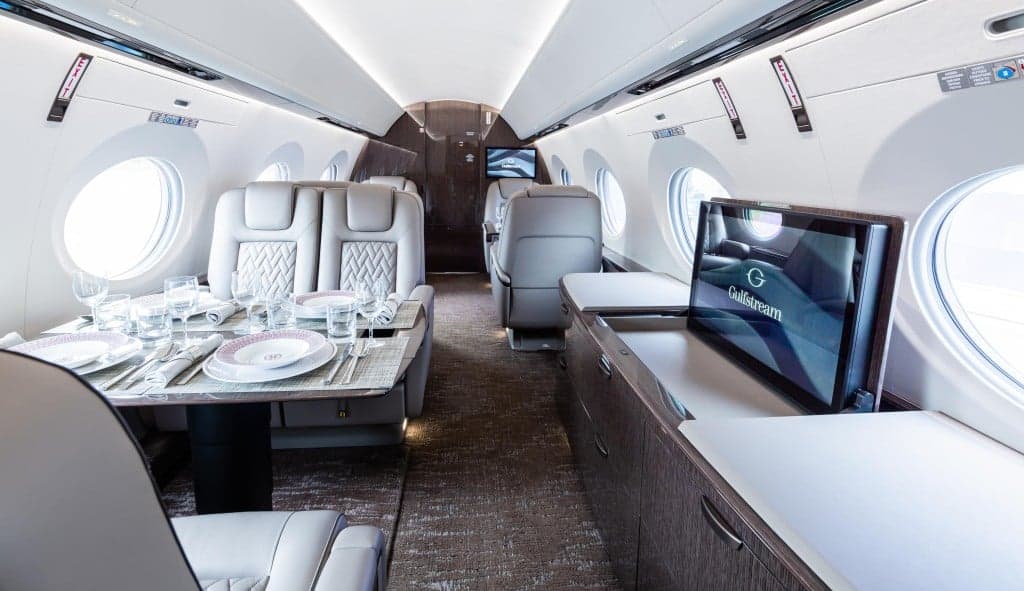 A gray Gulfstream aircraft is parked on the tarmac.