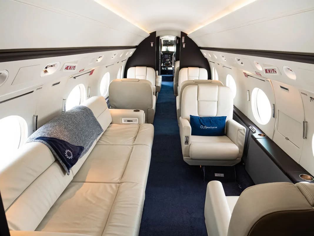 View of the aircraft interior with a white leather couch and seats.