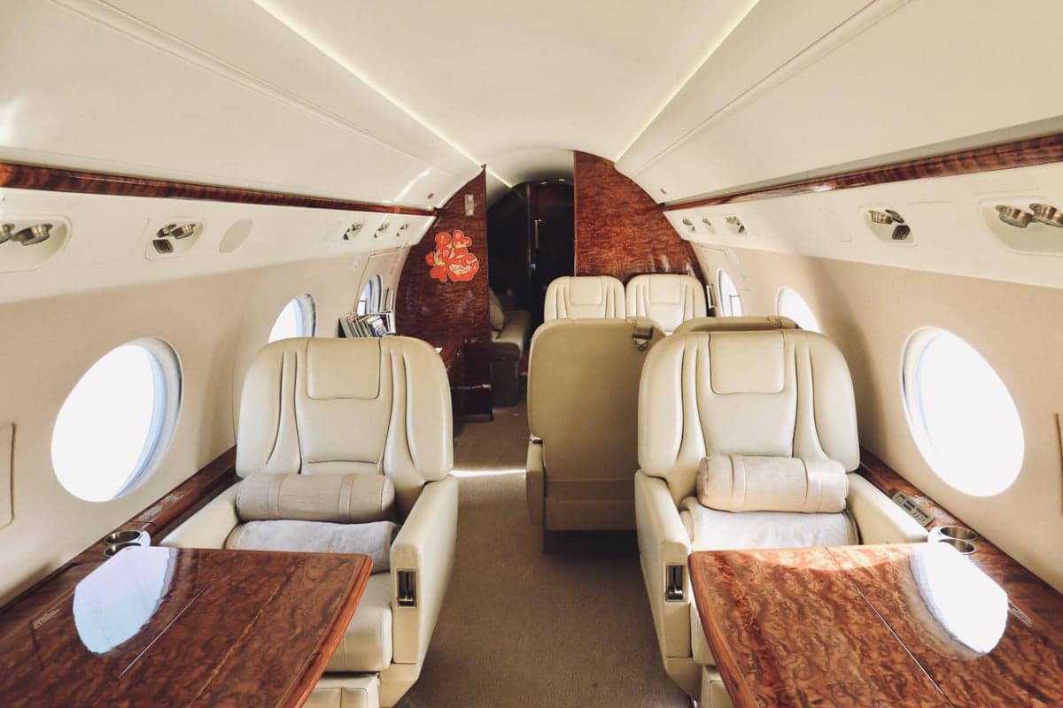 The interior of the aircraft features leather seats and wood tables.