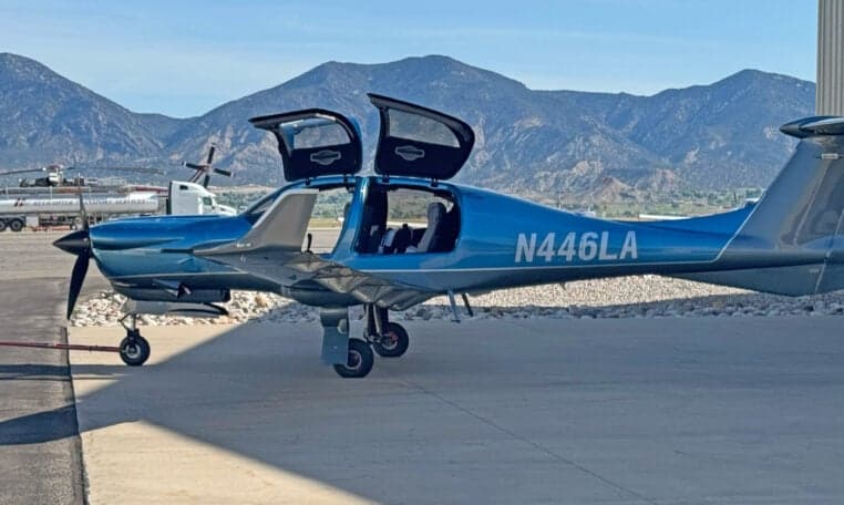 Diamond DA50 RG aircraft N446LA parked on the tarmac with mountains in the background.