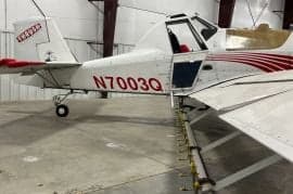 A white and red Air Tractor crop duster with the door open, showing the tail number N7003Q.
