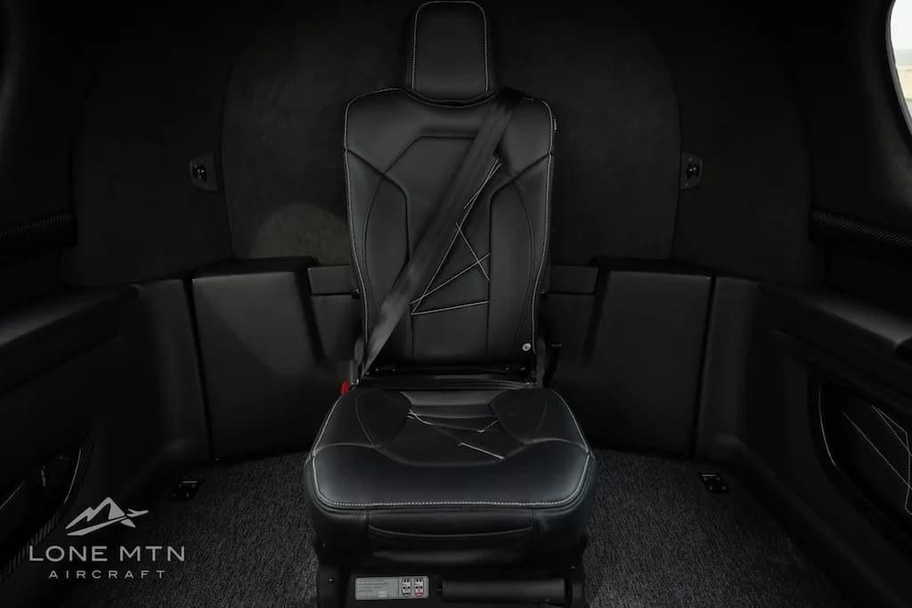 A single black leather passenger seat with white stitching in the cabin of the Cirrus Vision Jet.