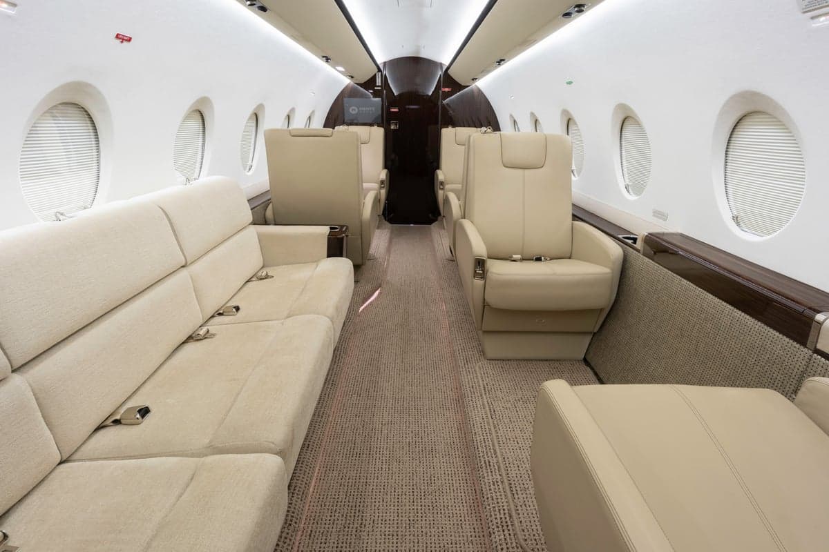 Interior view of the Gulfstream jet cabin with leather seats and a couch.