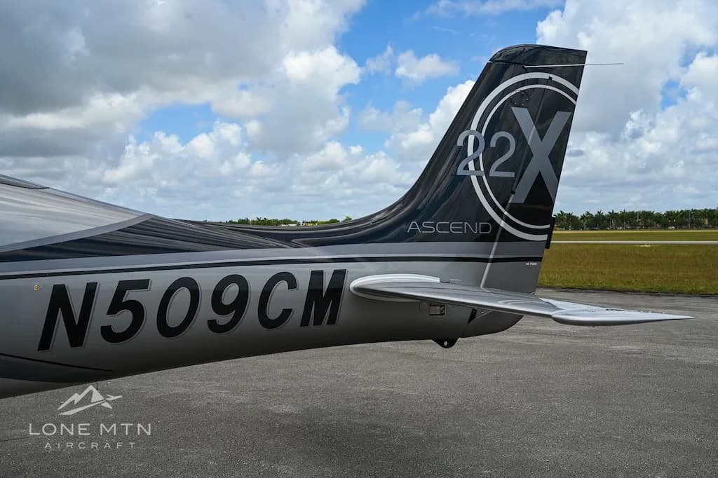 Close-up of the tail of a silver and black Cirrus SR22 aircraft, showing the registration N509CM and "ASCEND" branding.