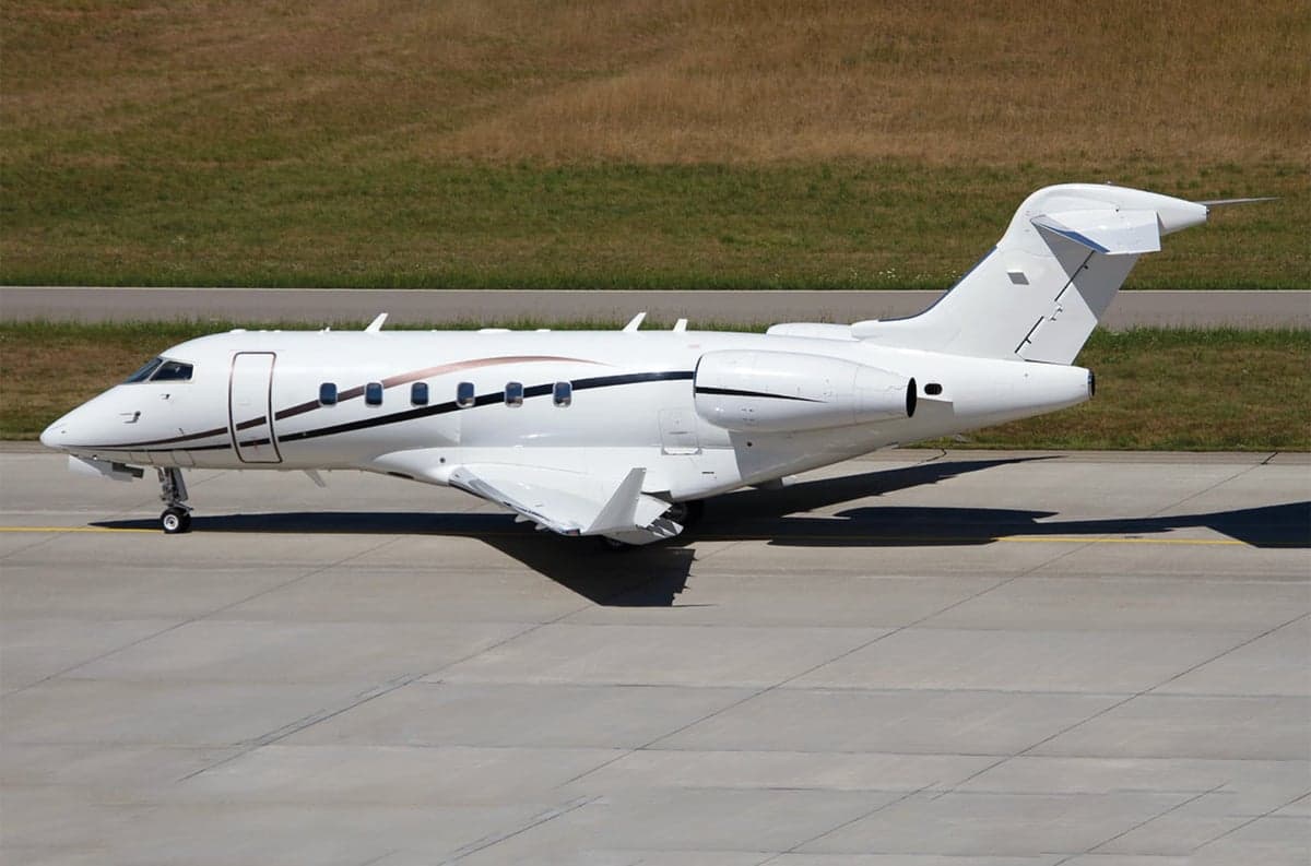 Side view of a white Bombardier Challenger on the tarmac.