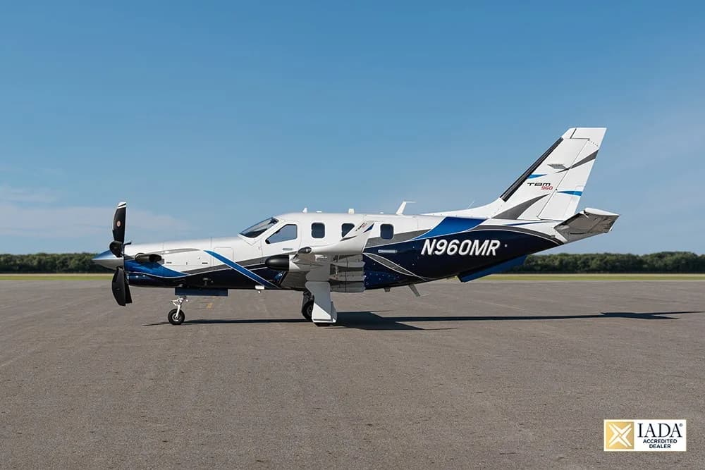 A TBM 960 aircraft with blue and white paint scheme, registration N960MR, parked on an airfield.