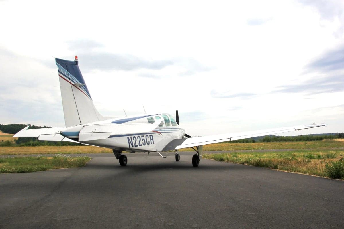Side view of N225CR Beechcraft Bonanza on the tarmac.